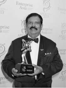 Graetian holding an Enterprise Asia award trophy during a formal recognition event