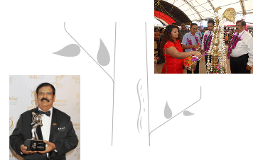 Business leader holding an award trophy and participating in a ceremonial event with traditional decorations